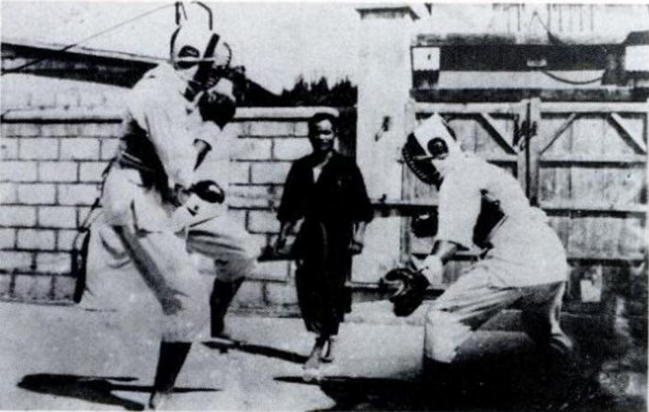Eizo leading a sparring match around 1958, seemingly using the gear developed by Tamotsu Isamu and the Renshinkan Shorinji-ryu. It was created in reference to Kendō protective gear, but for the use in Karate, with raw materials mainly being cloth and leather. There were many problems such as safety issues due to cracks, sanitary issues like becoming moldy, heavy and hard to move with, old design, and its high price.